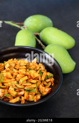 Grüner Mangosalat. Rohe Mango Instant Pickle. Auch bekannt als kairichi koshimbir in Marathi. Kopieren Raum auf schwarzem Hintergrund. Gehackte rohe grüne Mangos. Stockfoto