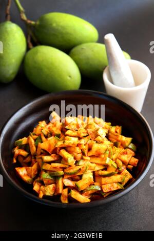 Grüner Mangosalat. Rohe Mango Instant Pickle. Auch bekannt als kairichi koshimbir in Marathi. Kopieren Raum auf schwarzem Hintergrund. Gehackte rohe grüne Mangos. Stockfoto