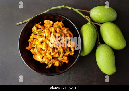 Grüner Mangosalat. Rohe Mango Instant Pickle. Auch bekannt als kairichi koshimbir in Marathi. Kopieren Raum auf schwarzem Hintergrund. Gehackte rohe grüne Mangos. Stockfoto