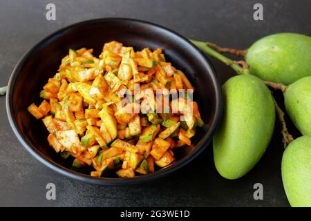 Grüner Mangosalat. Rohe Mango Instant Pickle. Auch bekannt als kairichi koshimbir in Marathi. Kopieren Raum auf schwarzem Hintergrund. Gehackte rohe grüne Mangos. Stockfoto