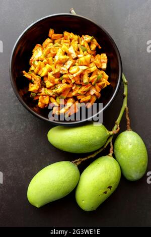 Grüner Mangosalat. Rohe Mango Instant Pickle. Auch bekannt als kairichi koshimbir in Marathi. Kopieren Raum auf schwarzem Hintergrund. Gehackte rohe grüne Mangos. Stockfoto