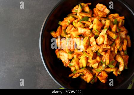 Grüner Mangosalat. Rohe Mango Instant Pickle. Auch bekannt als kairichi koshimbir in Marathi. Kopieren Raum auf schwarzem Hintergrund. Gehackte rohe grüne Mangos. Stockfoto