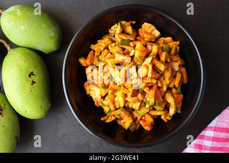 Grüner Mangosalat. Rohe Mango Instant Pickle. Auch bekannt als kairichi koshimbir in Marathi. Kopieren Raum auf schwarzem Hintergrund. Gehackte rohe grüne Mangos. Stockfoto