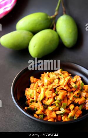 Grüner Mangosalat. Rohe Mango Instant Pickle. Auch bekannt als kairichi koshimbir in Marathi. Kopieren Raum auf schwarzem Hintergrund. Gehackte rohe grüne Mangos. Stockfoto