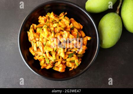 Grüner Mangosalat. Rohe Mango Instant Pickle. Auch bekannt als kairichi koshimbir in Marathi. Kopieren Raum auf schwarzem Hintergrund. Gehackte rohe grüne Mangos. Stockfoto