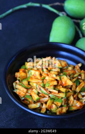 Grüner Mangosalat. Rohe Mango Instant Pickle. Auch bekannt als kairichi koshimbir in Marathi. Kopieren Raum auf schwarzem Hintergrund. Gehackte rohe grüne Mangos. Stockfoto