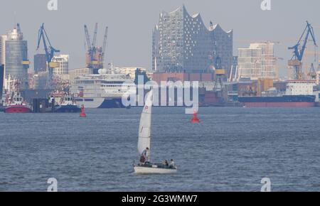Hamburg, Deutschland. Juni 2021. Auf der Elbe ist ein Segelboot unterwegs. Im Hintergrund ist die Skyline der Hansestadt Hamburg mit den Werftkranen und der Elbphilharmonie zu sehen. Kredit: Marcus Brandt/dpa/Alamy Live Nachrichten Stockfoto