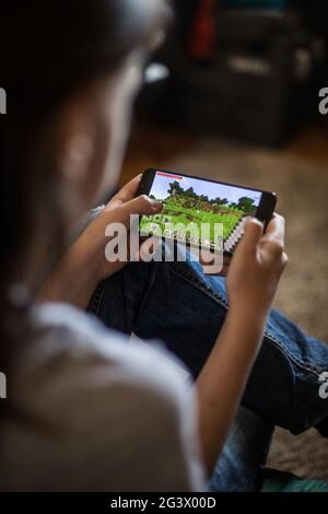 Bukarest, RUMÄNIEN - 10. Mai 2021: Illustrative redaktionelle Konzeptbild eines Kindes, das Minecraft-Spiel auf einem Mobiltelefon spielt. Stockfoto