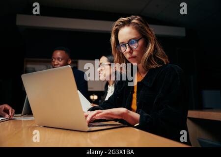 Porträt einer jungen Geschäftsfrau, die ihren Laptop benutzt, um sich mit ihrem Kollegen zu treffen Stockfoto
