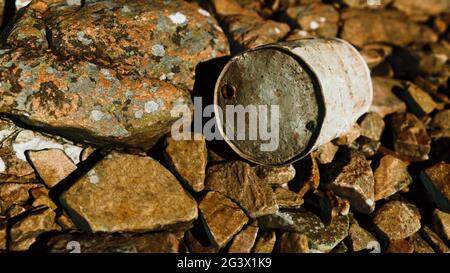 Rostig zerstörte Metallfass auf Strandfelsen Stockfoto