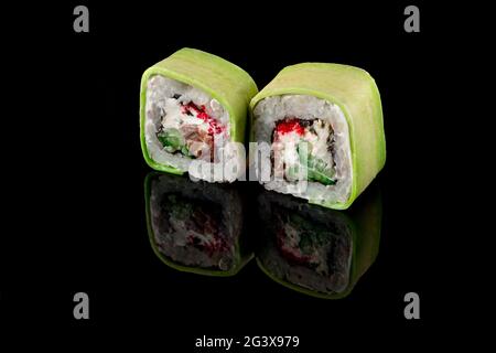 Grüne Rollen mit Thunfisch und grünem Kaviar und Garnelen auf schwarzem Hintergrund mit Spiegelung. Nahaufnahme, Draufsicht. Lieferung von Lebensmitteln Stockfoto