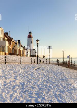 Schneebedeckter Strand während der Wnter durch Urk Leuchtturm in den Niederlanden Stockfoto