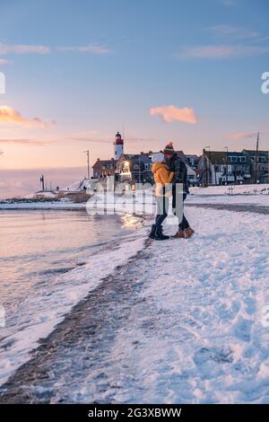 Paar Männer und Frauen am Leuchtturm von Urk Niederlande im Winter im Schnee Stockfoto