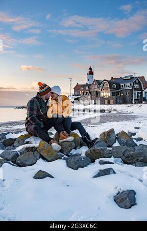 Paar Männer und Frauen am Leuchtturm von Urk Niederlande im Winter im Schnee Stockfoto