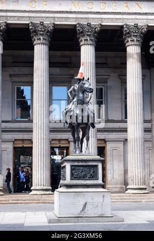 Reiterstatue von Arthur Wellesley, dem 1. Herzog von Wellington vor der Gallery of Modern Art, Glasgow.der Verkehrskegel auf seinem Kopf ist eine Tradition Stockfoto