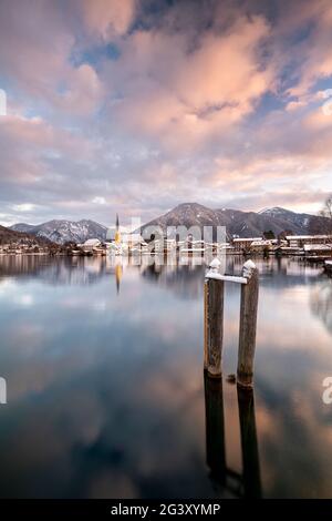 Blick über den winterlichen Tegernsee auf das Dorf Rottach-Egern mit der Kirche Sankt Laurentius, Bayern, Deutschland. Stockfoto