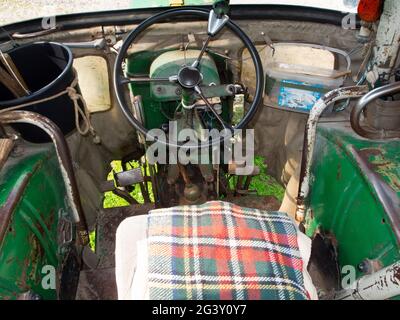 Innenansicht mit Blick durch die Windschutzscheibe eines restaurierten alten DEUTZ Traktors in Grün mit karierten Sitzkissen in der Nähe der Kleinstadt Nesselwa Stockfoto