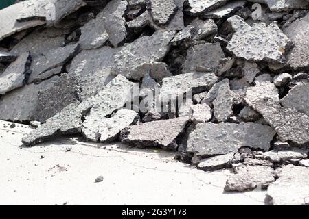 Gebrochener Asphalt. Teile einer asphaltierten Straße. Gebrochene Oberflächenstruktur der Straße. Gesprungener Asphaltstapel. Demontage der Autobahn. Stockfoto