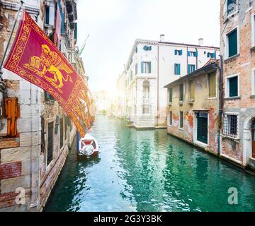 Venedig malerischer Kanal und Flagge der Venezianischen Republik Stockfoto