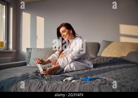 Positive erfreut junge weibliche Person tun Pediküre Stockfoto
