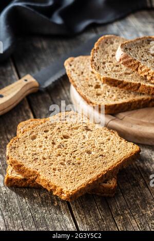 Geschnittenes Vollkornbrot auf einem Holztisch. Stockfoto