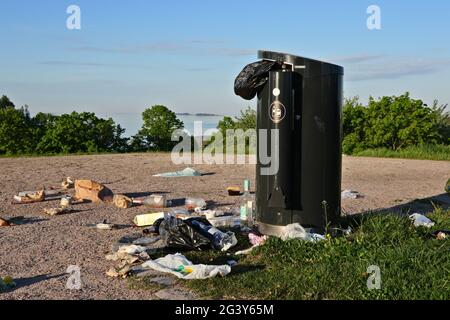 Müll und überlaufender Mülleimer im öffentlichen Park. Helsinki, Finnland. 5. Juni 2021. Stockfoto