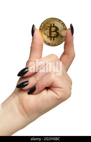 Weibliche Hand mit schwarzen Nägeln Maniküre und goldenen Bitcoin in den Fingern. Isoliert auf weißem Hintergrund. Stockfoto