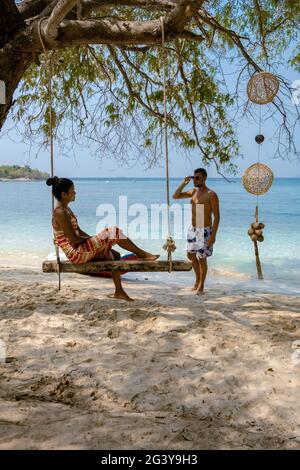 Ein Paar von hinten auf der Rückseite mit Blick auf den Ozean der tropischen Insel, wunderschöner tropischer Inselstrand - Koh Kham, trat T Stockfoto