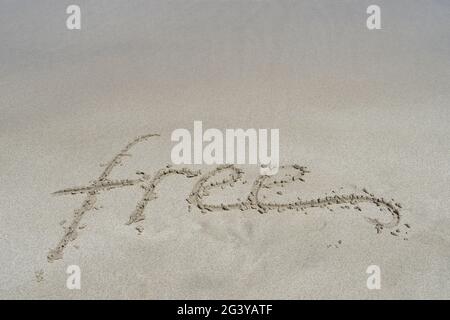 Kostenlose Emotionshandschrift in feinem Sand auf dem inspirierenden Hintergrund des Strandes Stockfoto