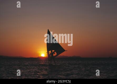 Australien. Queensland. Whitsunday Islands. Mann beim Windsurfen bei Sonnenuntergang. Stockfoto