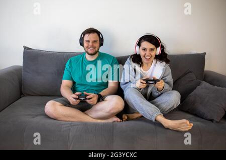 Paar spielen Videospiele zusammen sitzen auf dem Sofa Couch Stockfoto