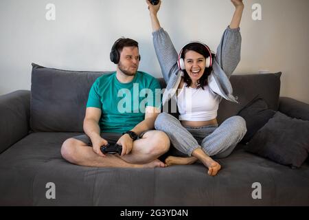 Paar spielen Videospiele zusammen sitzen auf dem Sofa Couch Stockfoto