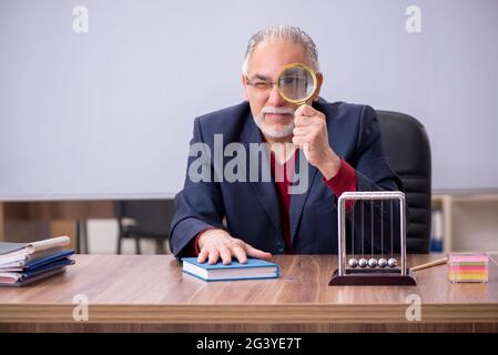 Alter Lehrer Physiker sitzt im Klassenzimmer Stockfoto