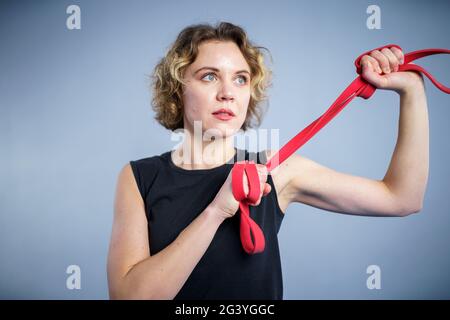 Sportliche Frau beim Training mit elastischen Widerstandsbändern im Fitnessstudio. Athletin Dame beim Training mit elastischem Band. Menschen, Sport, Fitness Stockfoto