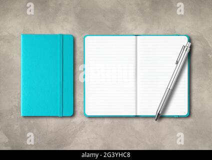 Aquablue, geschlossene und offene linierte Notizbücher mit einem Stift auf betontem Hintergrund Stockfoto