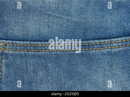 Nählinie aus braunen Fäden auf blauen Jeans Stockfoto