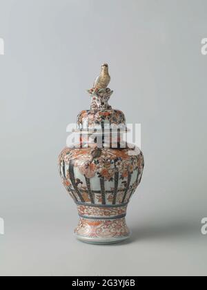 Bedecktes Baluster-Glas mit Figuren im Inneren hinter Rahmen, Prunus-Bäumen und Blumenrollen. Balusterförmige Deckeltopf aus Porzellan mit Spreizfuß, in Unterglasur blau und auf der Glasur rot, schwarz und Gold lackiert. An der Wand sitzen zweimal zwei Personen in einem Innenraum hinter einem gepflegten und bemalten Geländer. Dieses Geländer ist mit gepflegten und dekorierten prunus-Bäumen und Reifen mit Blumengetränken dekoriert. Unter dem Geländer eine Verbindung mit Blumengetränken. Eine Beziehung zu Lotusgetränken um den Fuß. Drei Kartuschen mit Lotusgetränken am Hals. Der Deckel mit der gleichen Dekoration; Deckel kn Stockfoto