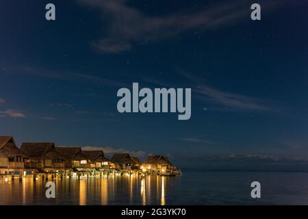 Überwasserbungalows des Sofitel Ia Ora Beach Resort in der Lagune von Moorea mit dem Kreuz des Südens am Sternenhimmel in der Nacht, Moorea, Windward is Stockfoto