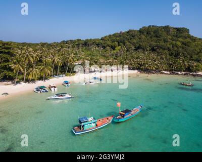 Luftaufnahme von Fischerbooten, die in der Bucht und am Strand mit Kokospalmen festgemacht sind, May Rut Island, in der Nähe von Phu Quoc Island, Kien Giang, Vietnam, Asien Stockfoto