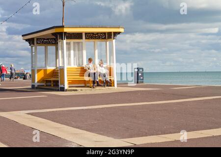 Southsea Seafront, im Oktober 2020, in der Sonne mit einem älteren Paar, das die Sonne während des Sperrens genießt. Stockfoto