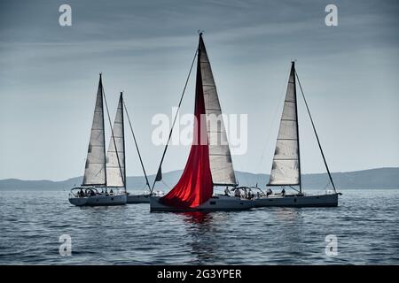 Das Rennen der Segelboote, eine Regatta, Reflexion der Segel auf dem Wasser, intensiver Wettbewerb, die Anzahl der Boote ist auf achtern Booten, hell colo Stockfoto