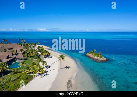 Luftaufnahme einer Residence Villa Unterkunft im Six Senses Fiji Resort mit Kokospalmen, einem Strand und einer Familie, die Wassersport-Aktivitäten genießt Stockfoto