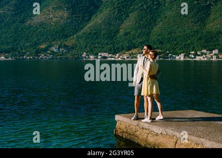 Ein verliebten Pärchen steht umarmt auf einem Pier in Die Bucht von Kotor in der Nähe von Perast vor der Kulisse der Grüne Pisten Stockfoto