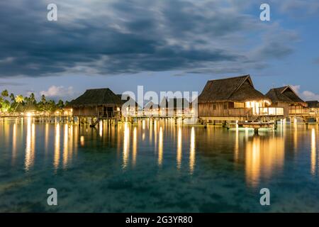 Überwasserbungalows des Sofitel Ia Ora Beach Resort in der Moorea-Lagune in der Abenddämmerung, Moorea, Windward Islands, Französisch-Polynesien, Südpazifik Stockfoto