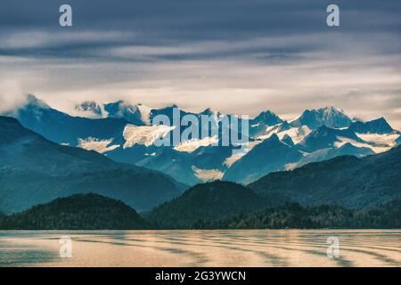 Die Alaska-Berge reichen von schneebedeckten Gipfeln in der Innenpassage, die Gletscherbucht-Naturlandschaft bei Sonnenuntergang im Herbst. Blick von der Kreuzfahrt. Stockfoto