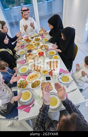 Muslimische Familie macht iftar dua Fasten während Ramadan zu brechen. Stockfoto