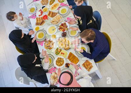 Draufsicht auf muslimische Familie, die während des Ramadan iftar dua zum Fastenbrechen macht. Stockfoto