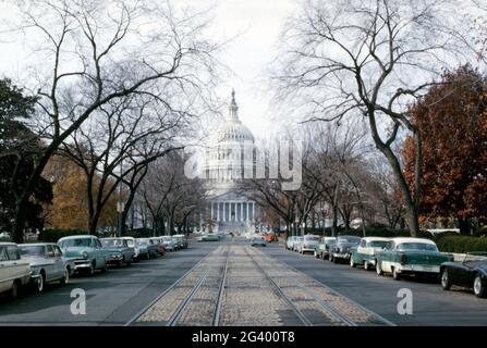 Das Kapitol der Vereinigten Staaten, Washington DC, USA, hier aus dem Osten entlang der East Capitol Street NE im Herbst 1962. Geparkte Autos säumen die Straße und die Straßenbahn-/Straßenbahnschienen befinden sich immer noch in der Mitte der Straße. Das Kapitol der Vereinigten Staaten, oft Kapitol oder Kapitolgebäude genannt, ist der Treffpunkt des Kongresses der Vereinigten Staaten und der Sitz der legislativen Abteilung der US-Bundesregierung. Das Capitol ist im neoklassischen Stil erbaut und hat eine weiße Fassade. Dieses Bild stammt von einem alten amerikanischen Amateur Kodak Farbtransparenz – einem alten Foto aus den 1960er Jahren. Stockfoto