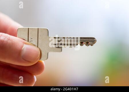 Einzug in ein neues Zuhause: Nahaufnahme einer Hand mit einem Schlüssel. Immobilien und Immobilien. Stockfoto