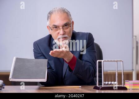 Alter Lehrer Physiker sitzt im Klassenzimmer Stockfoto